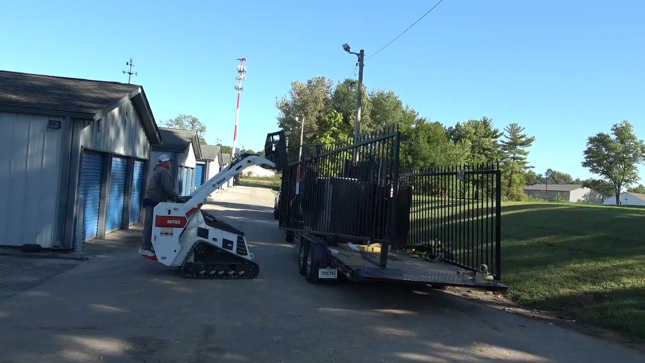 Track loader carrying the gate panel to the entry lane