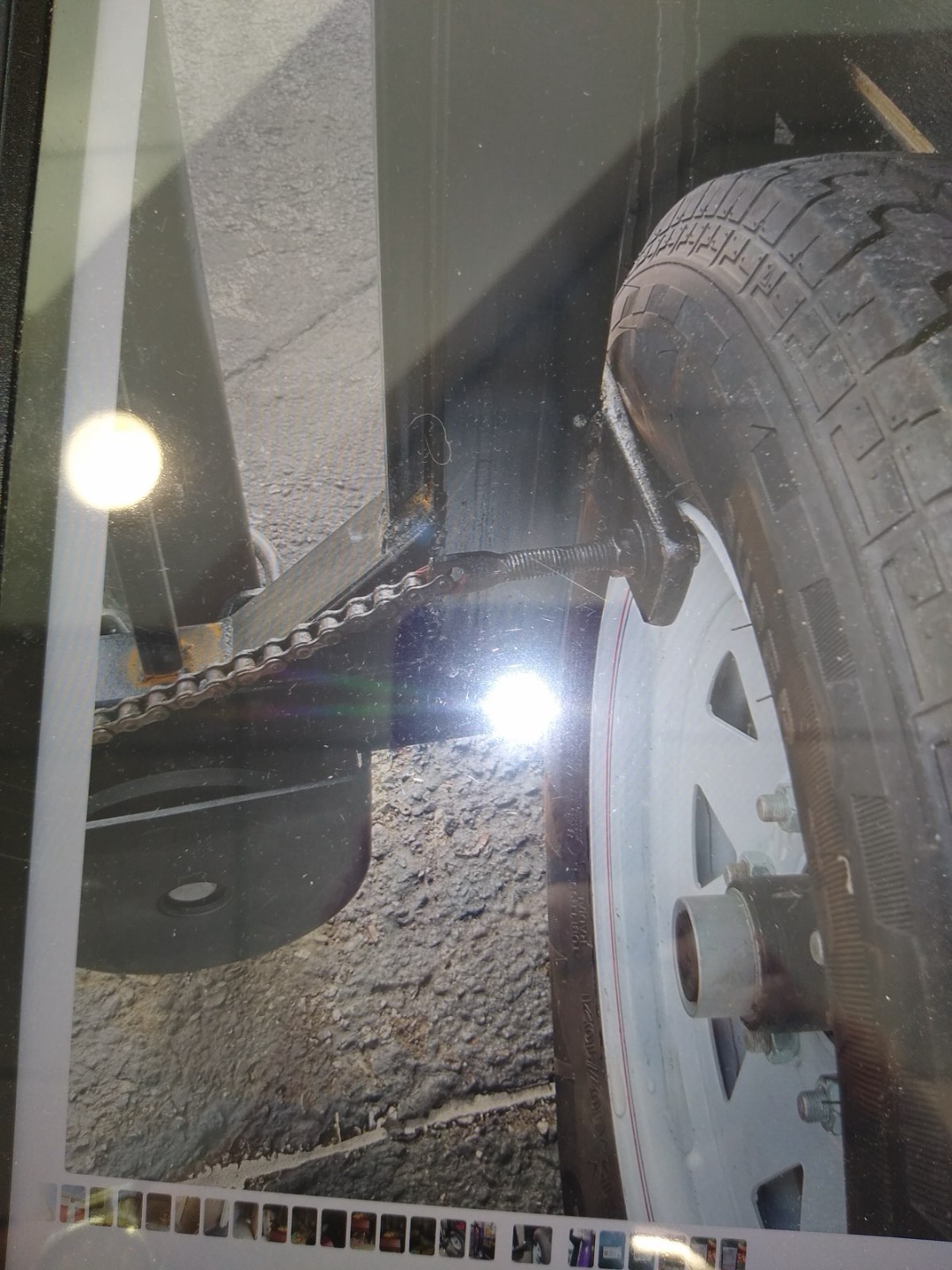 Gate rail lodged under trailer axle showing collision damage